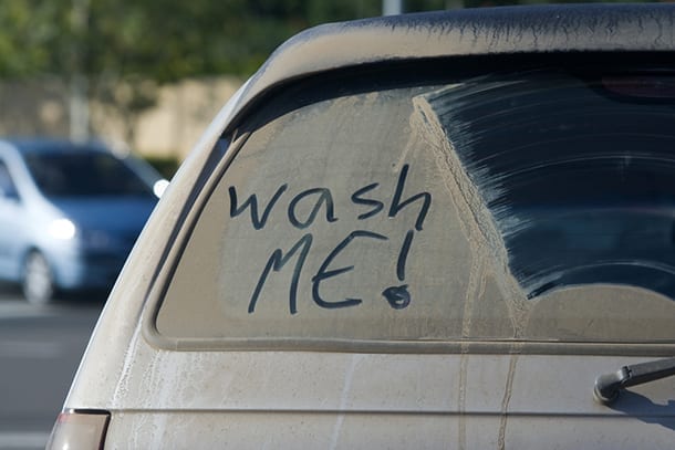 Dirty car with wash me! written on it