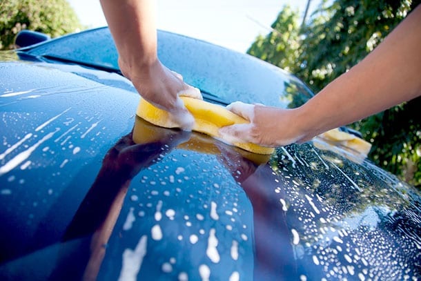 Guy washing blue car